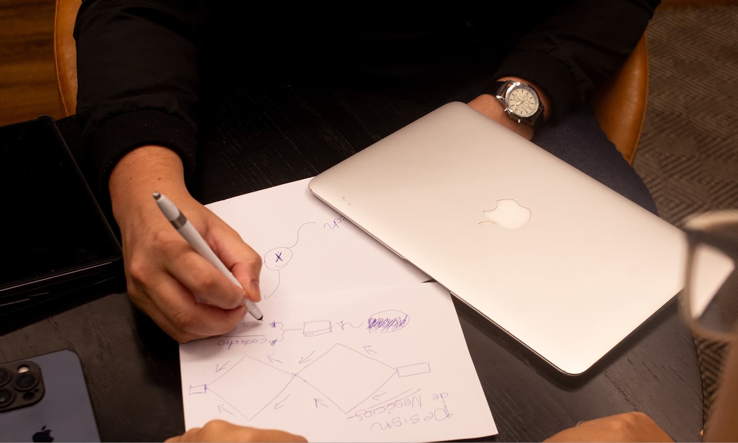 Fundo - mão escrevendo, laptop e smartphone