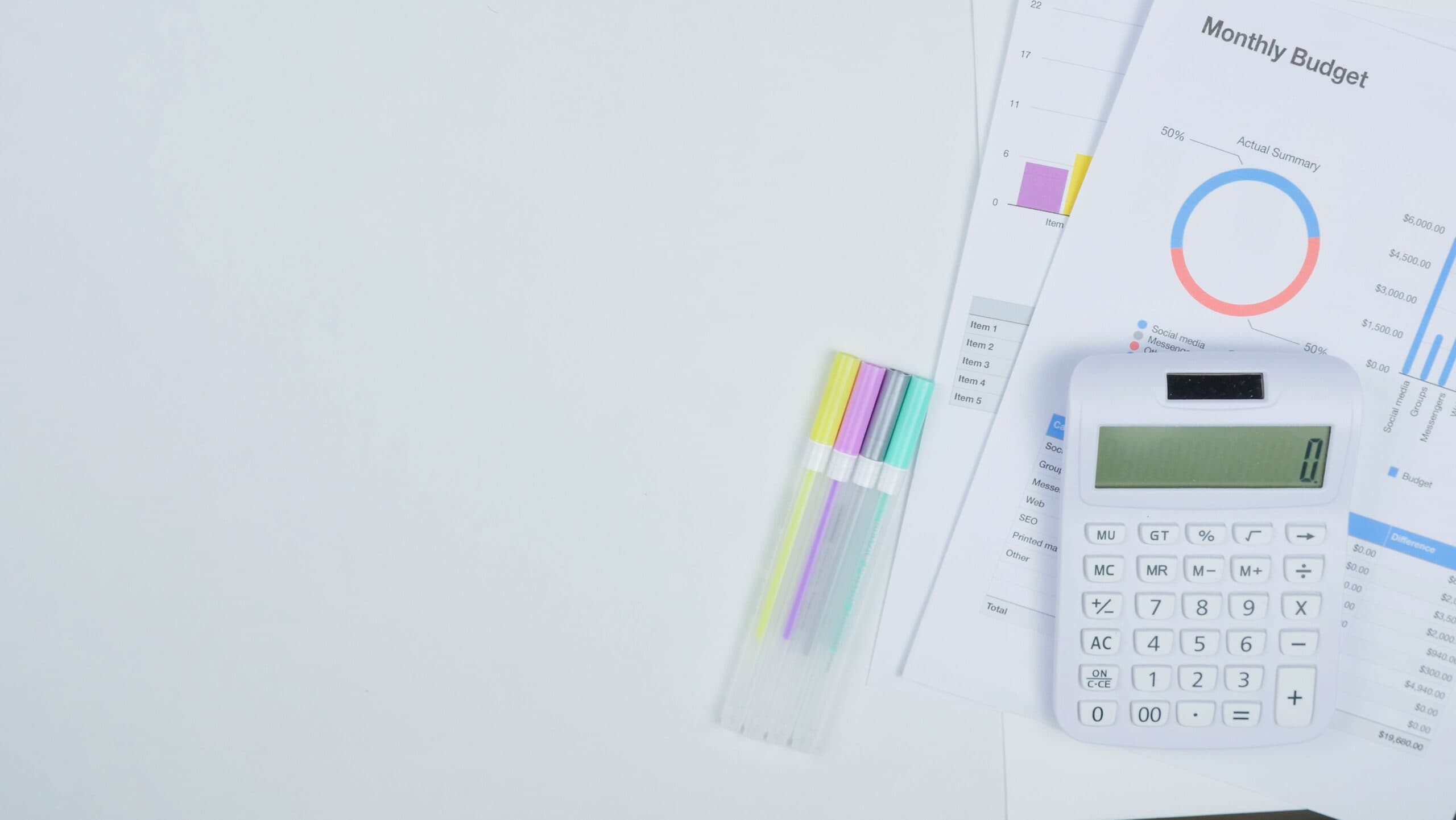 Mesa de trabalho com calculadora, documentos de planejamento de orçamento e canetas coloridas. Foto de Kindel Media via Pexels.